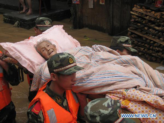Soldiers transfer an old woman trapped by the flood water at Songxi Town of Qingliu County, southeast China's Fujian Province, June 18, 2010.