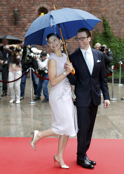 Sweden's Crown Princess Victoria and her fiance Daniel Westling pose under the umbrella during a Government reception at Stockholm City Hall June 18, 2010 as part of this weekend wedding celebrations. Sweden's Crown Princess Victoria and her fiance Daniel Westling will be married on June 19. 