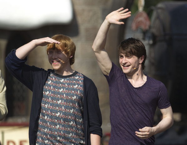 Daniel Radcliffe (R) and Rupert Grint from the 'Harry Potter' movies wave at fans gathered for the grand opening of The Wizarding World of Harry Potter theme park at the Universal Studio Resort in Orlando, Florida June 18, 2010.