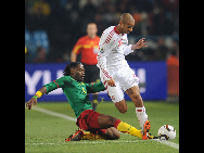 Cameroon's Rigobert Song (L) vies with Denmark's Simon Poulsen during their 2010 World Cup Group E soccer match at Loftus Versfeld stadium in Tshwane, South Africa, June 19, 2010.  [Xinhua] 