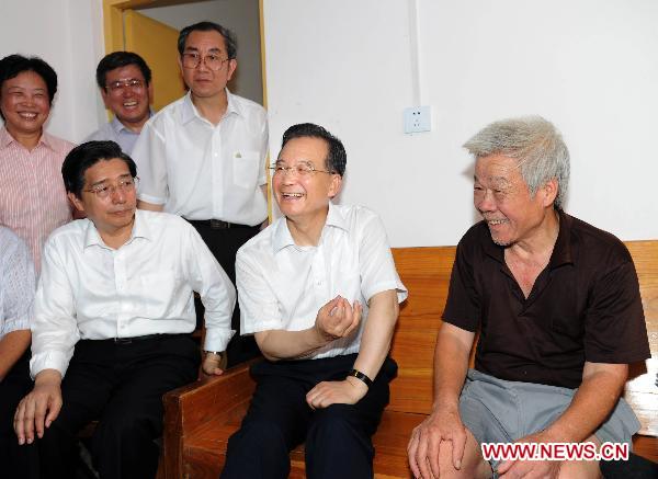 Chinese Premier Wen Jiabao (2nd R) talks with resident Luo Zhixiong during his visit to Wuzhou City of Guangxi Zhuang Autonomous Region June 19, 2010. Wen Jiabao inspected flood-affected area in Guangxi from June 19 to 20. (Xinhua/
