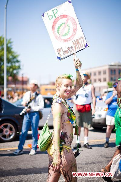 A woman holds a placard to protest against the oil spill pollution caused by the British Petroleum in the Gulf of Mexico during the annual Mermaid Parade in Coney Island, New York, the United States, June 19, 2010. The Mermaid Parade, characterized by participants dressed in hand-made costumes as Mermaids and various sea creatures, celebrates the sand, the sea, the salt air and the beginning of summer. [Xinhua] 