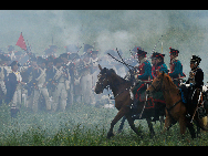 History enthusiasts, dressed as members of Allied Army, exercise at the bivouac of the famous battle of Waterloo in Waterloo, some 20 km south of Brussels, capital of Belgium, June 19, 2010. About 3,000 men across the Europe gathered in Waterloo this weekend to re-enact the crucial battle in 1815. [Xinhua]