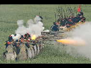 History enthusiasts, dressed as members of Allied Army, exercise at the bivouac of the famous battle of Waterloo in Waterloo, some 20 km south of Brussels, capital of Belgium, June 19, 2010. About 3,000 men across the Europe gathered in Waterloo this weekend to re-enact the crucial battle in 1815. [Xinhua]