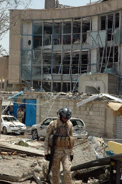 An Iraqi soldier is seen at blast site in Baghdad, capital of Iraq, June 20, 2010. At least 33 people were killed and 54 were wounded in two car bomb explosions in western Baghdad on Sunday. [Xinhua]