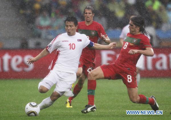 Hong Yong-Jo (L) of Democratic People's Republic of Korea (DPRK) vies with Pedro Mendes of Portugal during their 2010 World Cup group G soccer match at Green Point stadium in Cape Town, South Africa, June 21, 2010. (Xinhua/Xing Guangli) 