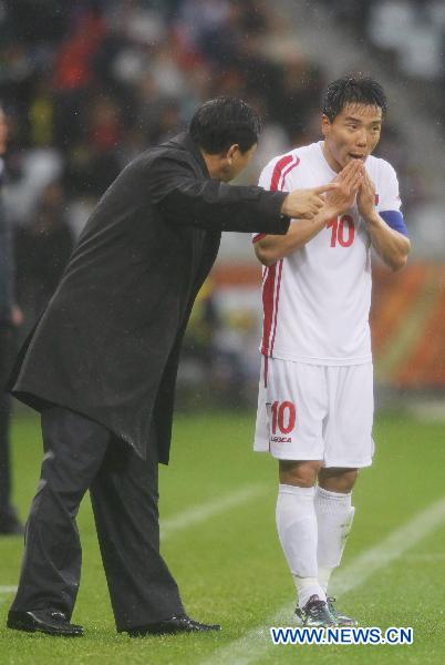 Head coach of Democratic People's Republic of Korea (DPRK) Kim Jong-Hun (L) talks to his player Hong Yong-Jo during the 2010 World Cup group G soccer match against Portugal at Green Point stadium in Cape Town, South Africa, June 21, 2010. (Xinhua/Xing Guangli)