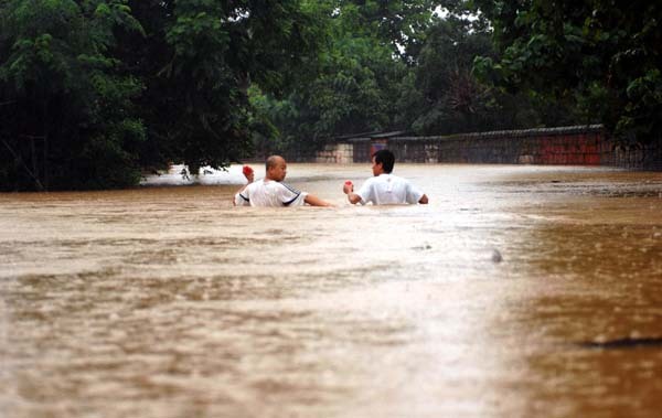 Residents wade through a flooded street in Yujiang County, east China's Jiangxi Province June 20, 2010. Persistent rain in ten regions of south China has left 175 people dead and 107 missing by 8 a.m. June 21, according to the figures released by the Office of State Flood Control and Drought Relief Headquarters and the Ministry of Civil Affairs.[Xinhua]