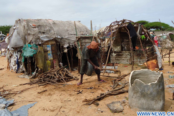 A refugee sets up a tent at a refugee camp in the Somali capital Mogadishu June 20, 2010. (Xinhua/Ismail Warsameh)