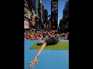 People gather to practice yoga on the morning of the summer solstice in New York's Times Square June 21, 2010. [Xinhua]