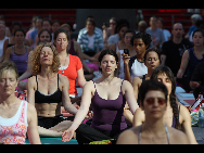 People gather to practice yoga on the morning of the summer solstice in New York's Times Square June 21, 2010. [Xinhua]