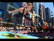 People gather to practice yoga on the morning of the summer solstice in New York's Times Square June 21, 2010. [Xinhua]