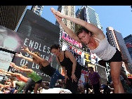 People gather to practice yoga on the morning of the summer solstice in New York's Times Square June 21, 2010. [Xinhua]