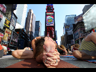 People gather to practice yoga on the morning of the summer solstice in New York's Times Square June 21, 2010. [Xinhua]