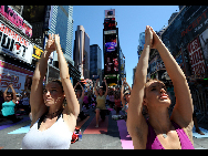 People gather to practice yoga on the morning of the summer solstice in New York's Times Square June 21, 2010. [Xinhua]