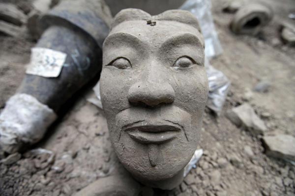 The head of a newly found terracotta warrior is placed at the excavation site inside the No 1 pit of the Museum of Qin Terracotta Warriors and Horses, on the outskirts of Xi&apos;an, Shaanxi province, June 21, 2010. [China Daily/Agencies]