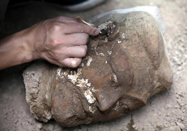 The head of a newly found terracotta warrior is placed at the excavation site inside the No 1 pit of the Museum of Qin Terracotta Warriors and Horses, on the outskirts of Xi&apos;an, Shaanxi province, June 21, 2010. [China Daily/Agencies] 