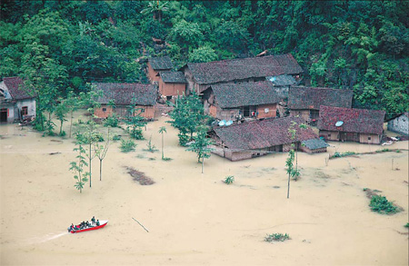Rescue workers drive a speedboat to a flooded village on Sunday in Nandan county of Guangxi Zhuang autonomous region. Rain-triggered floods and landslides have forced the evacuation of more than 1.7 million people in 10 southern provinces and regions, said the State Flood Control and Drought Relief Headquarters. [Xinhua]