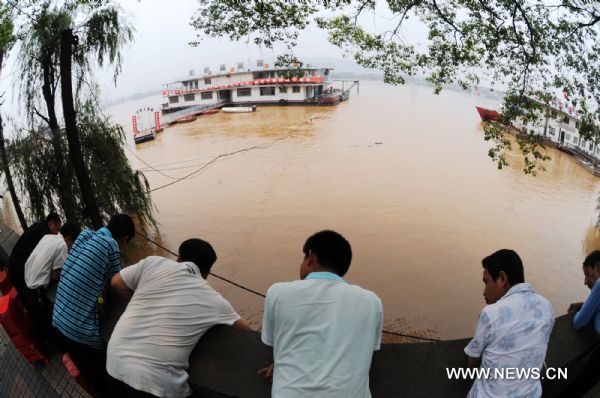 People look at the flooded Xiangjiang River in Changsha, central China's Hunan Province, June 21, 2010. Due to heavy rains and the flood discharge, the water level of Xiangjiang River at the Changsha section reached 36.33 meters at 1:00 pm on Monday, 0.33 meters above the warning level. [Xinhua]