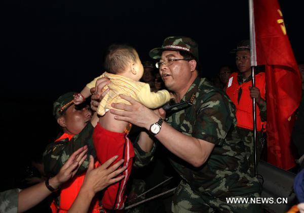 Paramilitary policemen help evacuate residents from Luozhen town of Fuzhou City, east China's Jiangxi Province, June 22, 2010.