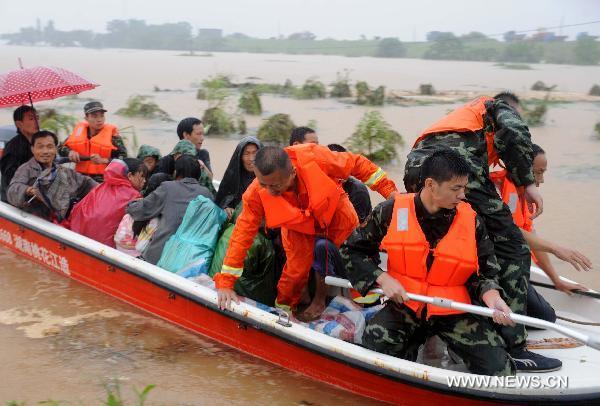 Paramilitary policemen help evacuate residents from Wanjia village of Fuzhou City, east China's Jiangxi Province, June 22, 2010. 