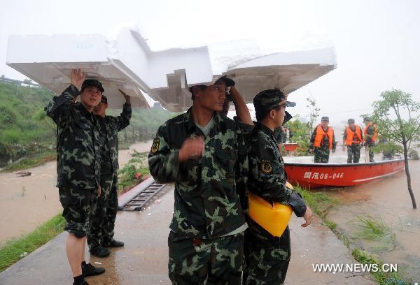 Paramilitary policemen conduct rescue operations after a dike bust in Fuzhou City, east China's Jiangxi Province, June 22, 2010.