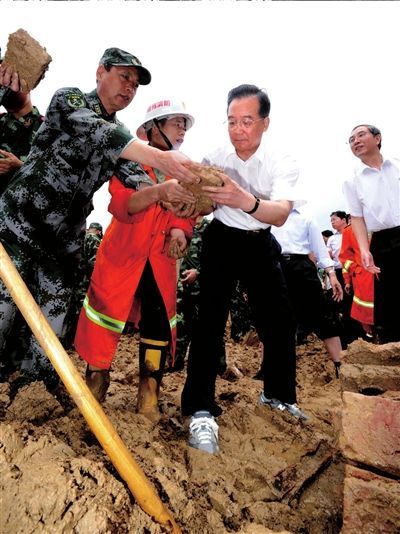 Chinese Premier Wen Jiabao (front R) cleans ruins with rescuers in Shuangshang village in Cangwu County of southwest China's Guangxi Zhuang Autonomous Region, June 20, 2010. Wen Jiabao inspected flood-affected area in Guangxi from June 19 to 20. [Xinhua]