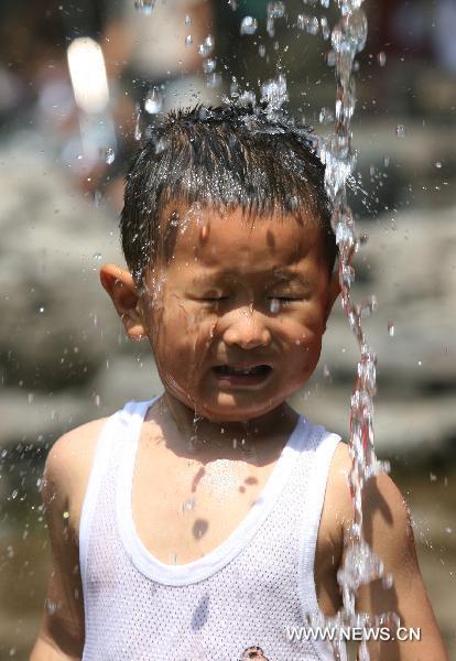 A boy plays at the Wulongtan spring in Jinan, capital of east China's Shandong Province, June 21, 2010.