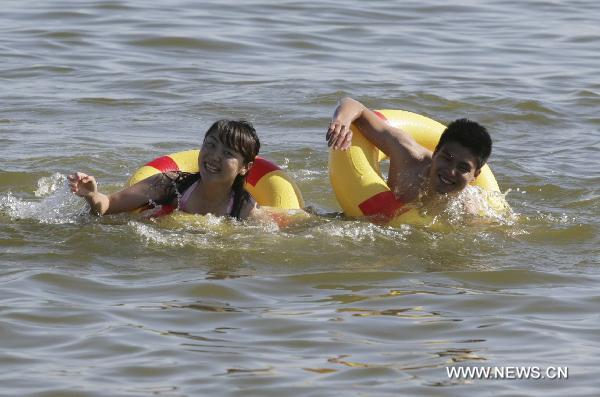 Tourists swim in the sea to cool themselves off in Qinghuangdao, north China's Hebei Province, June 21, 2010.