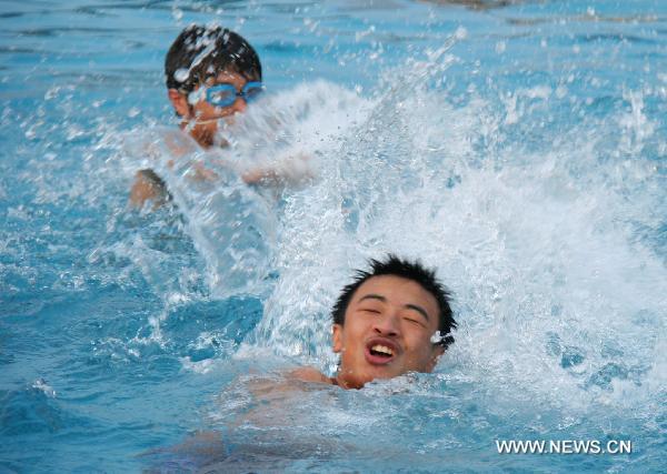 Men cool off in a pool in Linyi, east China's Shandong Province, June 21, 2010. 