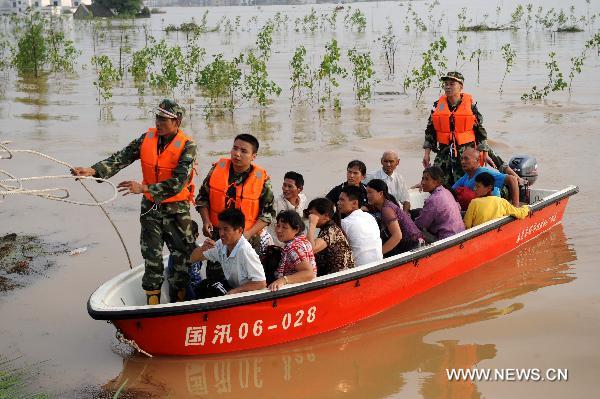 Fire fighters help the trapped villagers evacuate to safe places in Fuzhou City, east China's Jiangxi Province, June 22, 2010. The heavy rains and floods ravaging 10 southern Chinese provinces had killed 199 and left 123 missing as of Tuesday, according to the Ministry of Civil Affairs. [Xinhua]