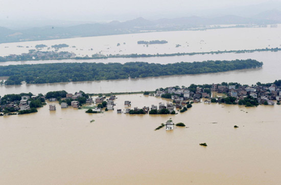Photo taken on June 22, 2010 shows a flooded village in Fuzhou, Jiangxi province. A dyke was breached nearby in the Fuhe River Monday night, endangering 145,000 residents. [Photo/Xinhua] 