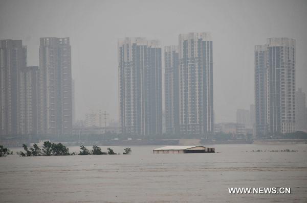 A house on the central shoal of the Ganjiang River is immersed in the flood, in Nanchang City, east China's Jiangxi Province, June 22, 2010. The flood peak of Ganjiang River is expected to pass Nanchang in the early morning on June 23.