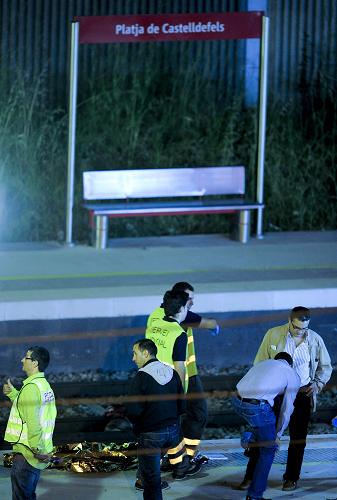 Police and rescue workers inspect the Castelldefels Playa station where a high-speed train passing through a Spanish railway station struck a group of people crossing the tracks, killing at least 12, in Castelldefels on June 24, 2010. 