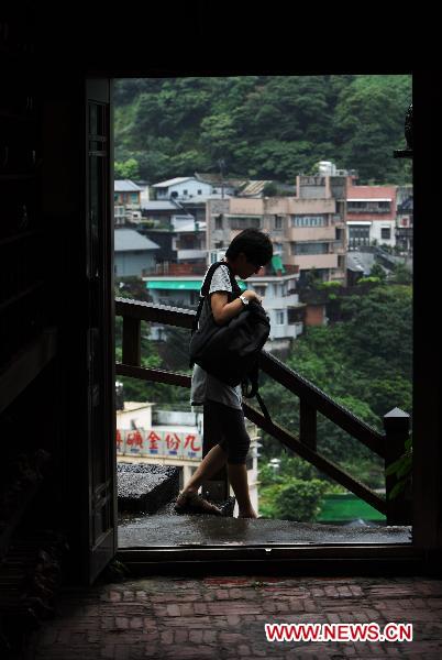 A tourist walks on an old street in the town of Jioufen in Rueifang Township of Taipei County, southeast China's Taiwan, June 23, 2010.