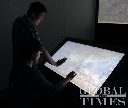 Reporters experience the multimedia system presenting Life along the Bian River at the Pure Brightness Festival, in the Palace Museum in Beijing, June 23, 2010.