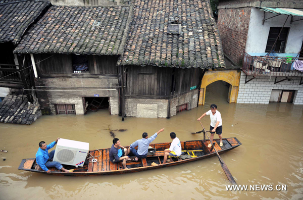 Locals transfer their belongings on a boat in Xiangtan County, central China&apos;s Hunan Province, June 24, 2010. Torrential rain and more water from its upper reaches had greatly driven up water levels in the Xiangjiang River.