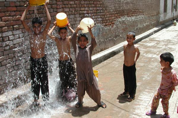Boys take bath on the road to protect themselves from heat wave in northwest Pakistan's Peshawar on June 25, 2010. At least 9 people have died in a heat wave across the country since last week. (Xinhua/Umar Qayyum) 
