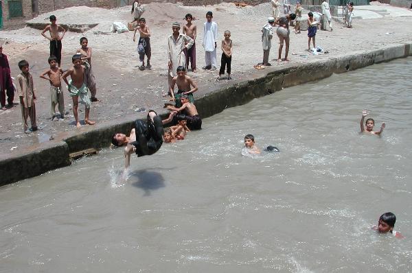 A boy jumps into the lake as a way to protect himself from heat wave in northwest Pakistan's Peshawar on June 25, 2010. At least 9 people have died in a heat wave across the country since last week. (Xinhua/Umar Qayyum) 