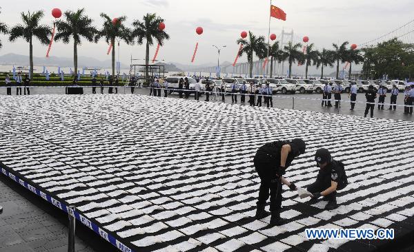 Police officers put packages of heroin seized after Huangpu Customs of Guangdong cracked a series of heroin trafficking cases in October 2009 in Humen, south China&apos;s Guangdong Province, on June 25, 2010. China&apos;s General Administration of Customs incinerated more than a tonne of smuggled drugs Friday here, on the eve of the 24th International Day Against Drug Abuse and Illicit Trafficking. [Xinhua]