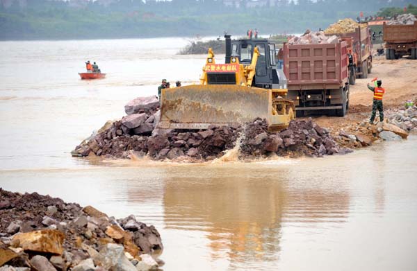 Soldiers work at the breach site of the dike at the Changkai section of the Fuhe River, in Fuzhou City, east China&apos;s Jiangxi Province, June 27, 2010. A dike breached after days of torrential rains in east China&apos;s Jiangxi Province was fixed on Sunday following around-the-clock repair efforts by hundreds of people.[Xinhua] 