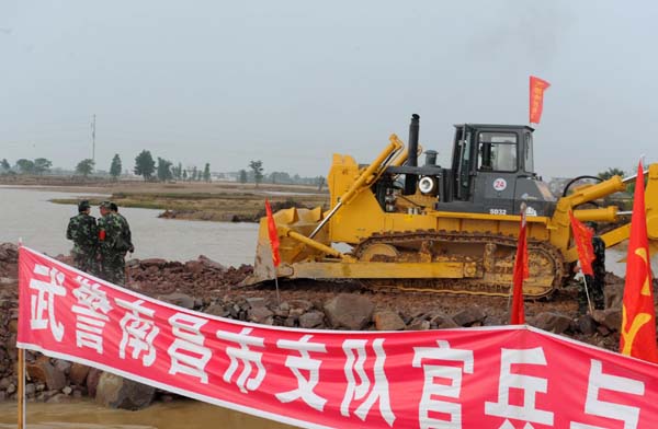 A large machine operates at the site where the Changkai Dike is repaired in east China&apos;s Jiangxi Province June 27, 2010. [Xinhua]