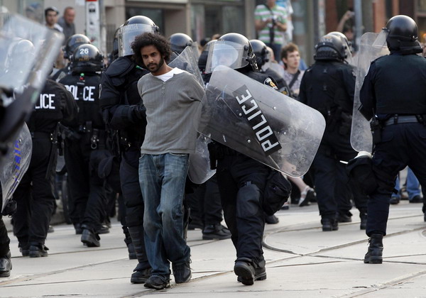 A protestor is arrested by police during a demonstration against the G20 summit in downtown Toronto, Canada June 26, 2010. [China Daily/Agencies]