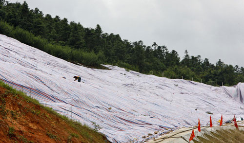 Hills are covered with waterproof materials to prevent landslides in Jianyang, East China&apos;s Fujian province, June 26, 2010. [Xinhua]