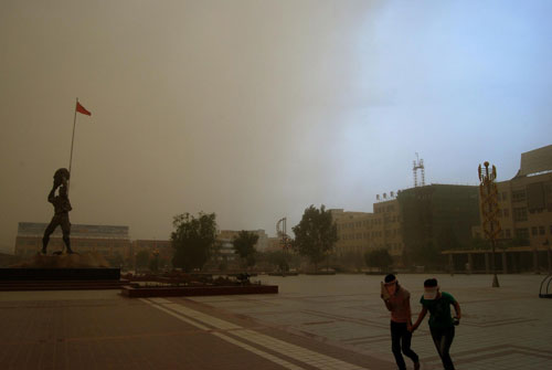 People drag through the sandstorm in Wuwei, Northwest China&apos;s Gansu province, June 27, 2010. [Xinhua]