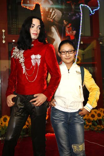 A visitor poses with the Michael Jackson tribute exhibit at the Shanghai World Expo, June 25, 2010. 