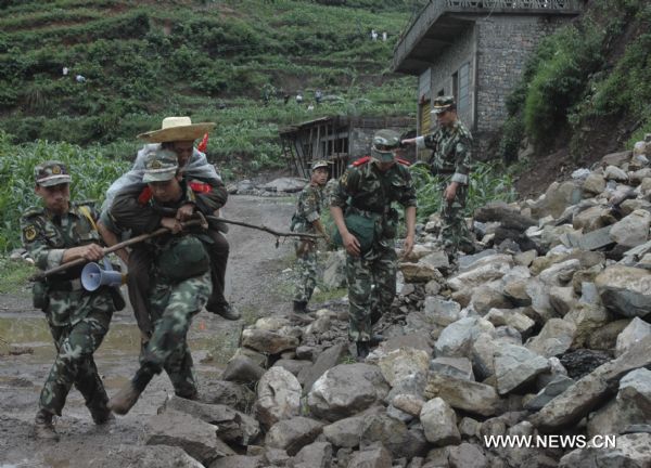 Soldiers evacuate a resident from the site of a landslide in Dazhai Village, Guanling County of southwest China&apos;s Guizhou Province, on June 28, 2010. Some 107 people from 38 families were buried and trapped by a rainstorm-triggered landslide Monday afternoon in southwest China&apos;s Guizhou Province, local authorities said. [Xinhua] 