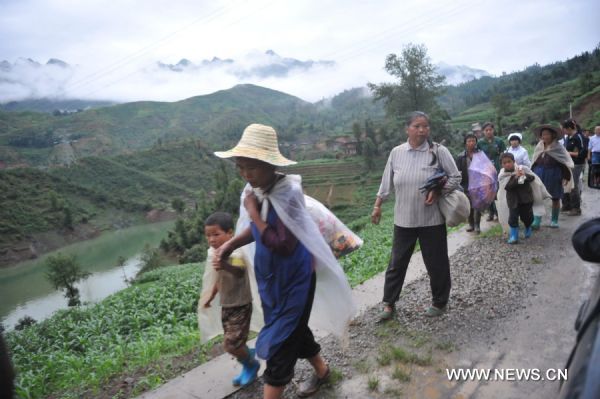 Local residents evacuate from the site of a landslide in Guanling County of southwest China&apos;s Guizhou Province, on June 28, 2010. Some 107 people from 38 families were buried and trapped by a rainstorm-triggered landslide Monday afternoon in southwest China&apos;s Guizhou Province, local authorities said. [Xinhua]