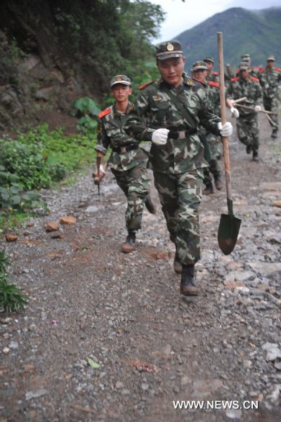 Soldiers rush to the site of a landslide in Guanling County of southwest China&apos;s Guizhou Province, on June 28, 2010. Some 107 people from 38 families were buried and trapped by a rainstorm-triggered landslide Monday afternoon in southwest China&apos;s Guizhou Province, local authorities said. [Xinhua]