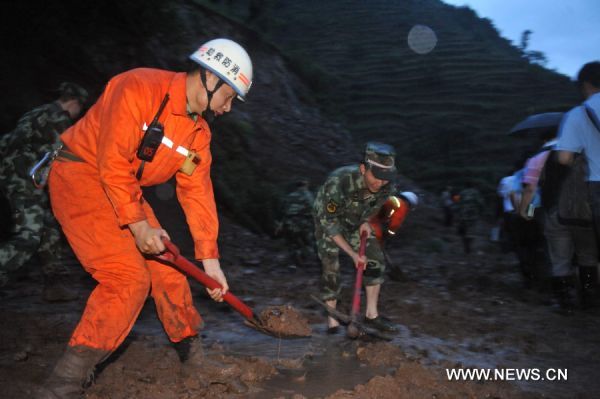 Soldiers try to clear a road covered by mud after a landslide in Guanling County of southwest China&apos;s Guizhou Province, on June 28, 2010. Some 107 people from 38 families were buried and trapped by a rainstorm-triggered landslide Monday afternoon in southwest China&apos;s Guizhou Province, local authorities said. [Xinhua]